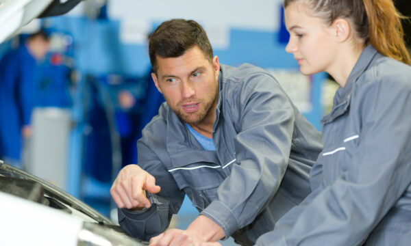 Mechanics fixing the engine of a van